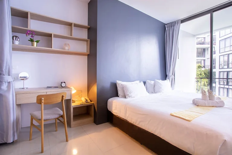 Schlafzimmer in Icon Park mit Schreibtisch und Balkontür