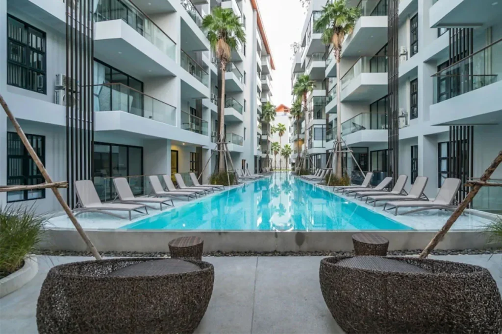 Swimming pool between the Palmyrah Surin buildings with sun loungers