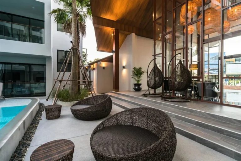 Lounge with rattan seats beside the pool at Palmyrah Surin