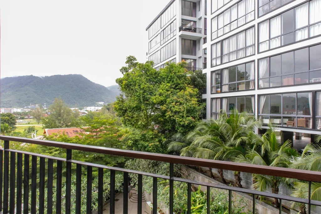 Blick von einem Balkon in Icon Park über die Bäume zu den Hügeln von Kamala