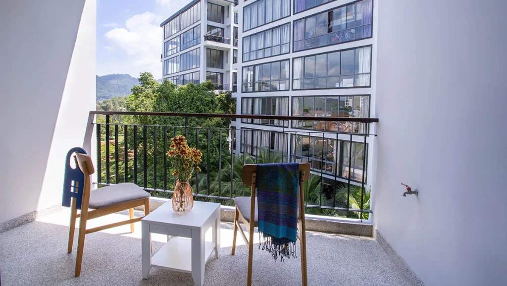 Balkon mit zwei Stühlen und Blick auf die Gärten und Gebäude von Icon Park