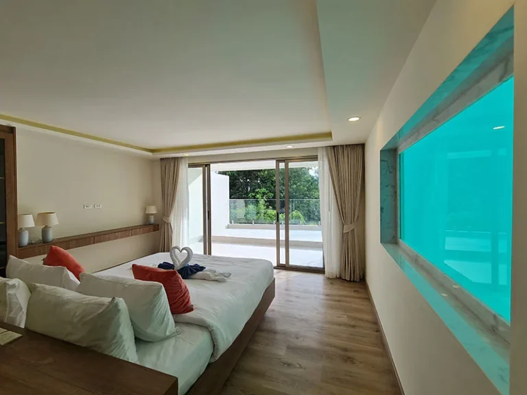 Bedroom at Ocean Town Kata with a window into the private pool