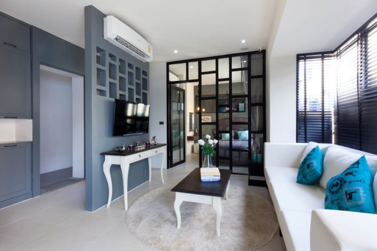 Living area at Palmyrah Surin with a white sofa and a glass partition