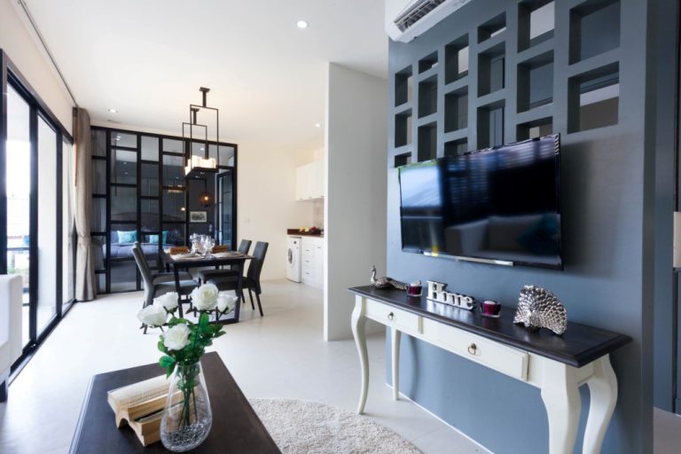 Living room at Palmyrah Surin with a TV wall and a dining table
