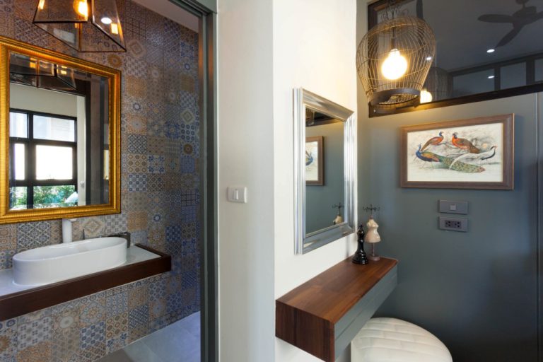Bathroom vanity at Palmyrah Surin with a gold-framed mirror