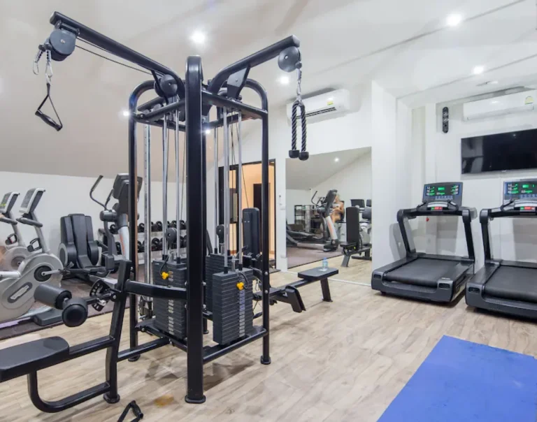 Fitness room at Palmyrah Surin with a weight station and treadmills